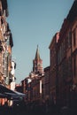 Vertical shot of the tower of the basilica St Sernin in Toulouse and a crowded street