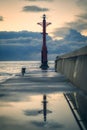 Vertical shot of a tower with light on the edge of dock during the sunset