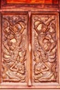 Vertical shot of traditional carved wooden door of Wat Pahuaylad