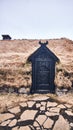 Vertical shot of a traditional old Viking house with a black door in front in Iceland