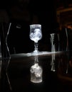 Vertical shot of transparent and fragile glass with ice reflected on the table