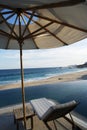 Vertical shot of a trestle and umbrella next to infinity pool on the sandy beach of Caribbean sea Royalty Free Stock Photo