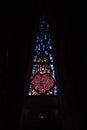 Vertical shot of the triangle stained glass window in dark background.