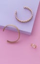 Vertical shot of two bracelets and ring on pink and purple background with copy space Royalty Free Stock Photo