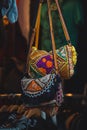 Vertical shot of two colorful hand-made female bags hanging on the street market in Amsterdam