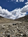 Vertical shot of two garbage bags on the rocks by a road with mountains and clouds in the background Royalty Free Stock Photo