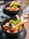 Vertical shot of two servings of Caesar salad with chicken, quail egg, cherry tomatoes, croutons and basil in dark blue bowls on a