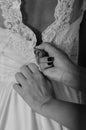 Vertical shot of an unrecognizable bridesmaid dressing bride in the morning in hotel room