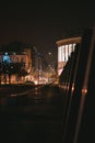 Vertical shot of an urban street in a city and cars in a heavy traffic at night