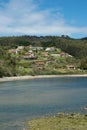 Vertical shot with a view of El Puntal. Residential houses on a hill, forest around. River arriving to Atlantic Ocean. Spot for