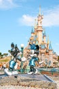 Vertical shot of the view to Disneyland with a fairy tale castle behind statue of mickey and Minnie Royalty Free Stock Photo