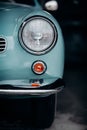 Vertical shot of vintage blue Volkswagen Karmann Ghia in the garage