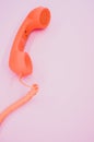 Vertical shot of a vintage orange telephone on a pink background Royalty Free Stock Photo