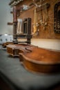 Vertical shot of a violin in the process of luthiery with restoration tools hang on the background Royalty Free Stock Photo