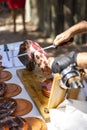 Vertical shot of a waiter cutting the slices of tasty Jamon