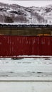 Vertical shot of a wall behind the forest covered in snow Royalty Free Stock Photo