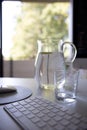 Vertical shot of water carafe with glass on table Royalty Free Stock Photo