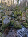 Vertical Shot Of Water Cascade Flowing Through Big Rocks In The Forest