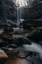 Vertical shot of a waterfall cascading down between large rocks Royalty Free Stock Photo