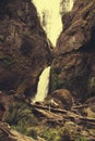 Vertical shot of a waterfall falling from the middle of enormous rocks