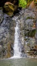 Vertical shot of a waterfall flowing over huge rocks Royalty Free Stock Photo