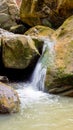 Vertical shot of a waterfall flowing over huge rocks Royalty Free Stock Photo