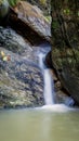 Vertical shot of a waterfall flowing over huge rocks Royalty Free Stock Photo