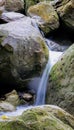 Vertical shot of a waterfall flowing over huge rocks Royalty Free Stock Photo