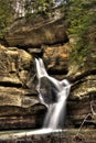 Vertical shot of a waterfall surrounded by rocks in the Hocking Hills State Park in Ohio, the US Royalty Free Stock Photo