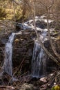 Vertical shot of waterfalls through rocks with long exposure in the forest Royalty Free Stock Photo