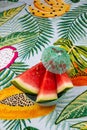 Vertical shot of watermelon wedges in a bowl on colorful tablecloth,decorated with a tiny umbrella