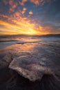 Vertical shot of the waves at the Dead Sea covering the sand during the sunset