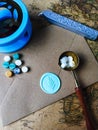 a vertical shot of wax coin with ribbon, wax bead on grey surface