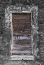 Vertical shot of a weathered closed window on a wooden wall