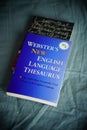 Vertical shot of Webster's New English Language Thesaurus on a bed