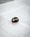 Vertical shot of a wedding ring on the page of the Bible Royalty Free Stock Photo