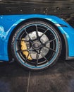 Vertical shot of a wheel of a blue Porsche Carrera wheel