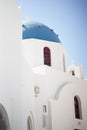 Vertical shot of the white Blue Domed Church under a blue sky in Santorini, Greece Royalty Free Stock Photo