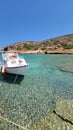 Vertical shot of a white boat in the harbor on the island with a clear water Royalty Free Stock Photo