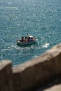 Vertical shot of a white boat in the ocean in Peniche, Portugal