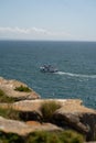 Vertical shot of a white boat in the ocean in Peniche, Portugal