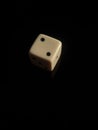 Vertical shot of white dice showing two pips isolated on a black background Royalty Free Stock Photo