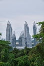 Vertical shot of white glassy buildings of Singapore surrounded by green nature under the calm sky Royalty Free Stock Photo