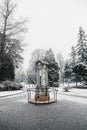 Vertical shot of a white and gray shed in front of fir trees covered in snow Royalty Free Stock Photo