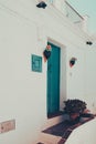 Vertical shot of a white house with a bright blue door decorated in Frigiliana, Spain