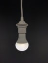 Vertical shot of  white lamp turned on over black background Royalty Free Stock Photo