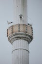 Vertical shot of a white minaret with speakers.