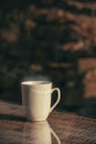 Vertical shot of white mug on reflecting table glass with blur background, perfet for wallpaper