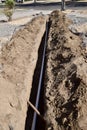 Vertical shot of a white pipeline going through the ground