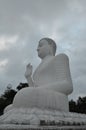 Vertical shot of a white sitting Budha in Mihintale Temple, Sri Lanka